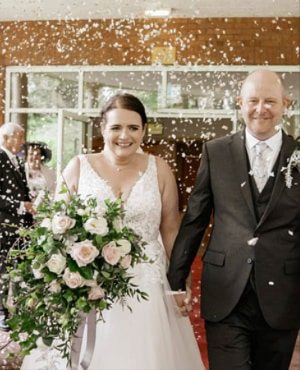 Bride and groom with large wedding bouquet - Marshalls Wedding Flowers
